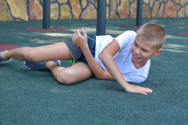 niño cayó y golpeó en el patio al aire libre lesión de rodilla lesión deportiva infantil