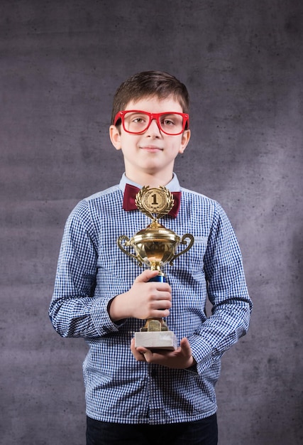 Niño celebra su trofeo de oro