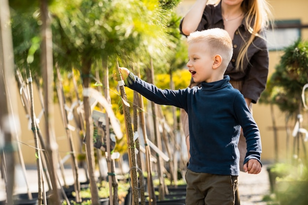 Niño en el centro de jardinería con su madre