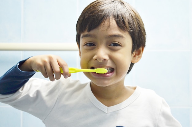 Niño cepillándose los dientes con una sonrisa