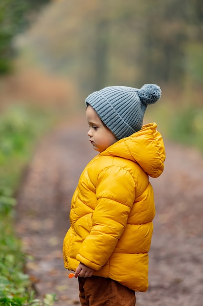 Elevado George Stevenson violencia Niño de chaqueta amarilla quedarse solo en el bosque | Foto Premium