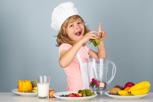 Niño chef aislado en azul divertido niño pequeño chef cocinero vistiendo uniforme gorro de cocinero y delantal cocinado foo