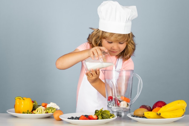 Niño chef aislado en azul hacer batido de leche batido divertido niño pequeño chef cocinero vistiendo uniforme cocinero