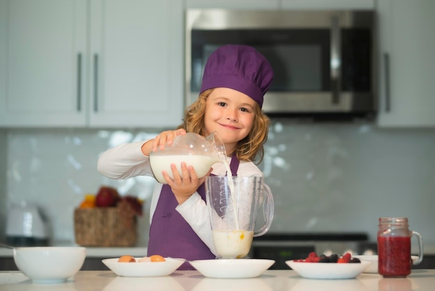 Niño chef preparó ingredientes niño chef en delantal y sombrero de chef cocinando en la cocina comida saludable