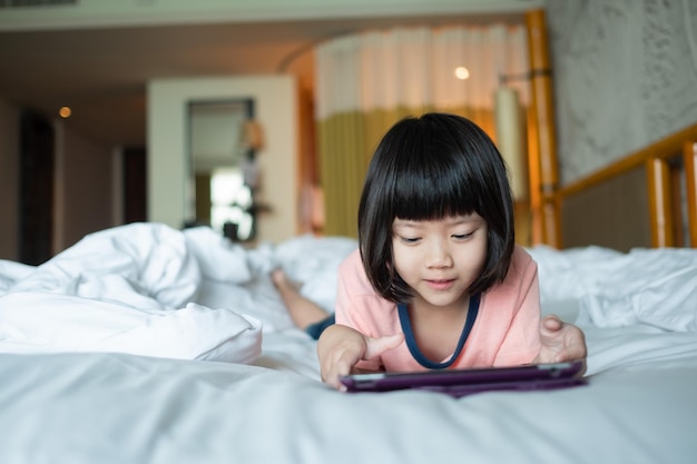 Niño chino adicto al teléfono que usa el teléfono para ver el teléfono inteligente