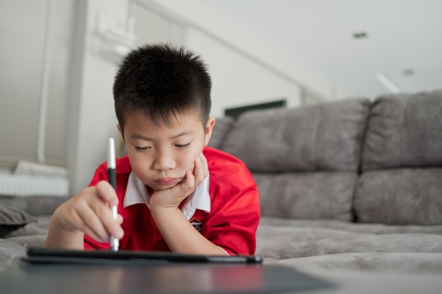 niño chino asiático jugando teléfono inteligente niño usa el teléfono y juega juegos adictos y dibujos animados