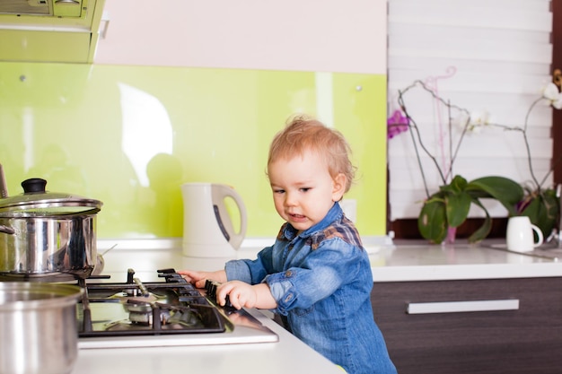 Foto el niño en la cocina intenta encender la estufa de gas y se prepara para comer