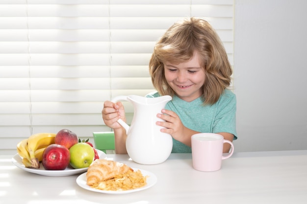 Niño en la cocina en la mesa comiendo vegetales y frutas durante la cena comida saludable v