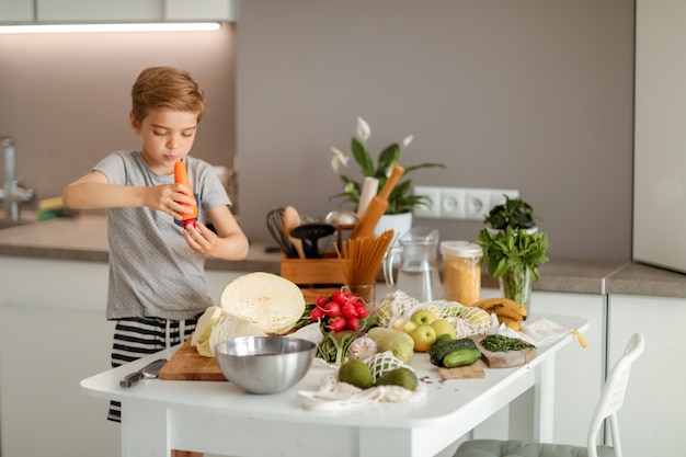 Un niño cocinando con verduras en la cocina