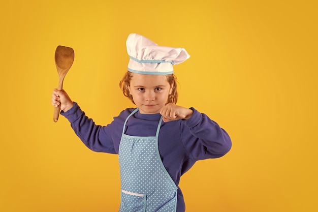 Foto niño cocinero con cucharón de cocina niño chef cocinero prepara comida en un estudio aislado fondo niños cocinando adolescente niño con delantal y sombrero de chef preparando una comida saludable