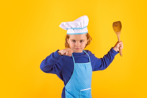 Niño cocinero con cucharón de cocina Niño chef cocinero prepara comida sobre fondo de estudio aislado