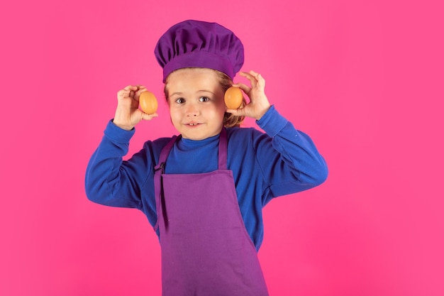 Niño cocinero sostiene huevos Chef niño preparando comida saludable Retrato de niño con gorros de chef