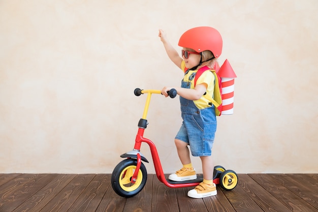 Foto niño con cohete de papel jugando en interiores