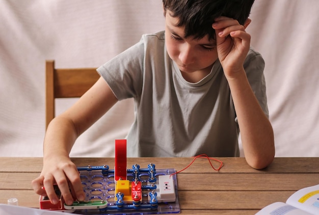 Foto niño colecta juguetes educativos de constructor electrónico desarrollo de niños en edad preescolar