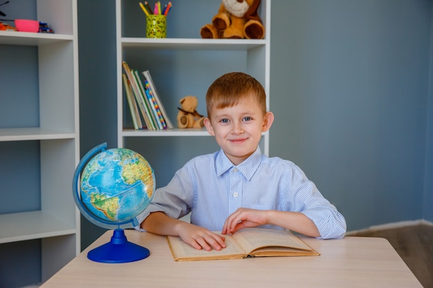 Un niño colegial lee un libro en la escuela. Concepto de educacion