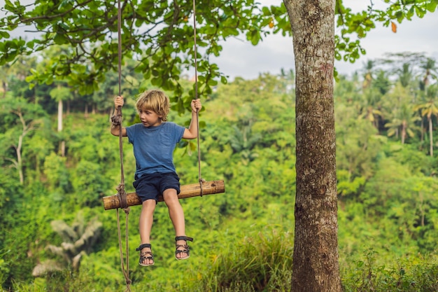 Niño en el columpio en Campuhan Ridge Walk en Ubud, Bali.