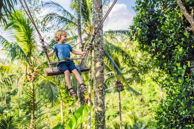 Un niño en un columpio sobre la jungla, Bali.