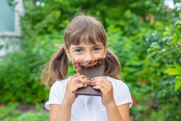 El niño come una barra de chocolate.