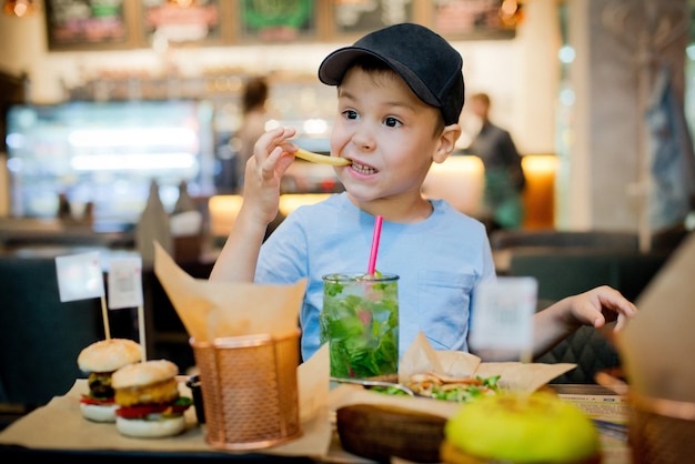 Un niño come comida rápida.