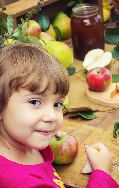 El niño come miel y manzanas. Enfoque selectivo