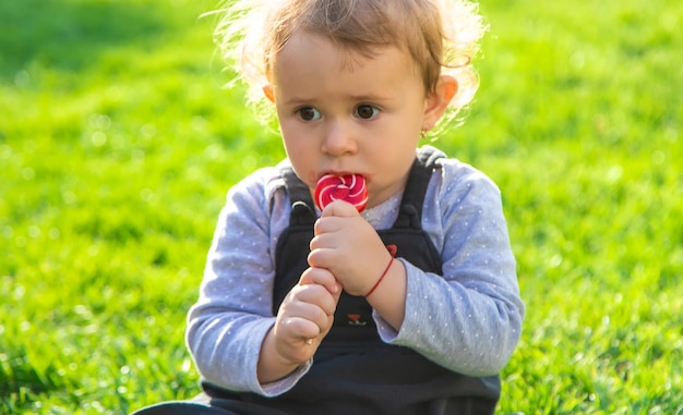 Un niño come una piruleta en el parque Enfoque selectivo