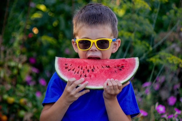 Un niño se come una sandía enfoque selectivo naturaleza