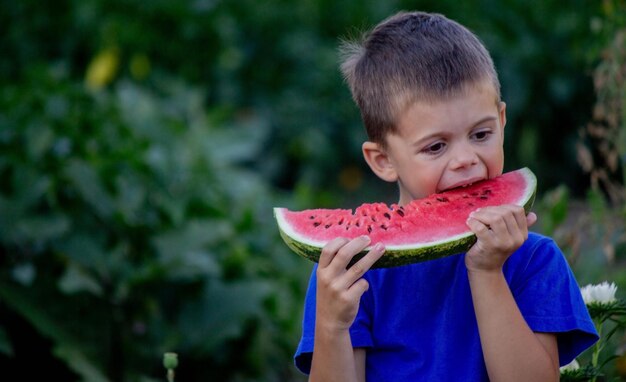 Un niño se come una sandía enfoque selectivo naturaleza