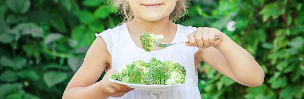 El niño come verduras. Foto de verano Enfoque selectivo