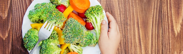 El niño come verduras. Foto de verano Enfoque selectivo