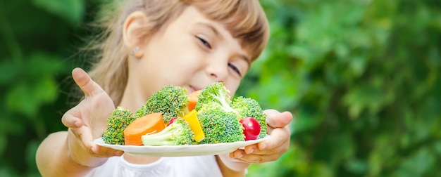 El niño come verduras. Foto de verano Enfoque selectivo