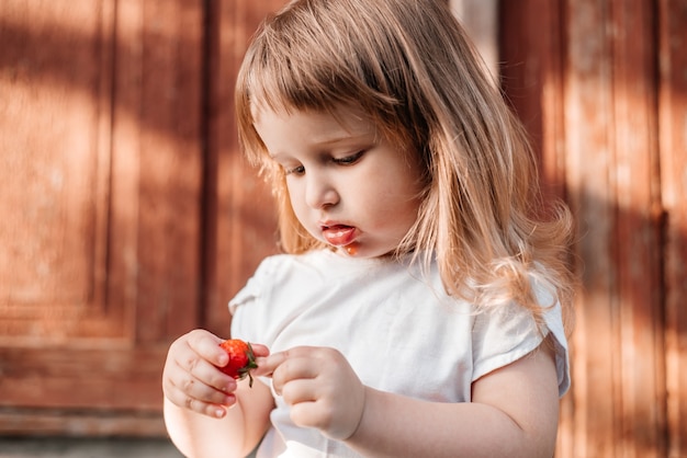 Niño con comida. Fresa de alimentación saludable.