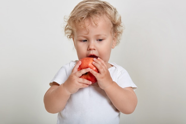 Niño comiendo alimentos saludables, niño rubio de pelo ondulado