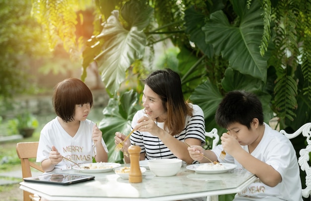 Niño comiendo comida con la madre, tiempo feliz, desayuno