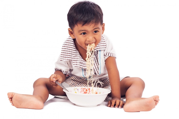 Niño comiendo fideos