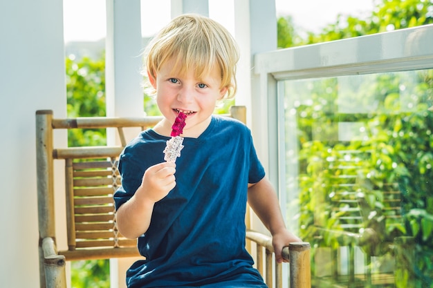 Niño comiendo fruta del dragón al aire libre