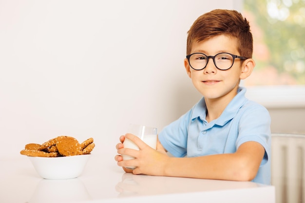 Niño comiendo galletas con leche