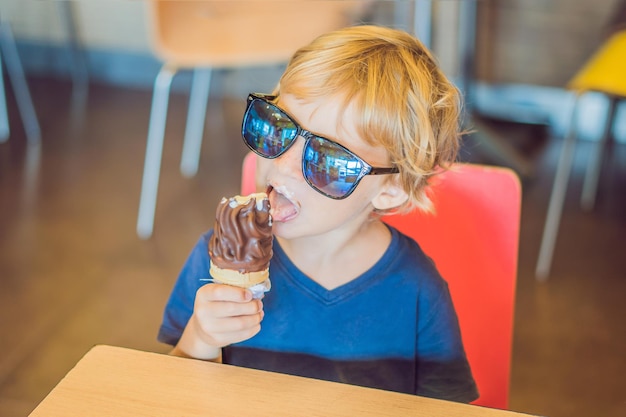 Niño comiendo helado en un café.