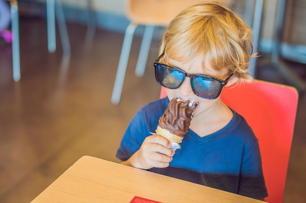 Niño comiendo helado en un café.