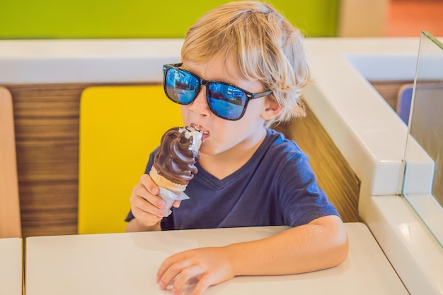 Niño comiendo helado en un café.