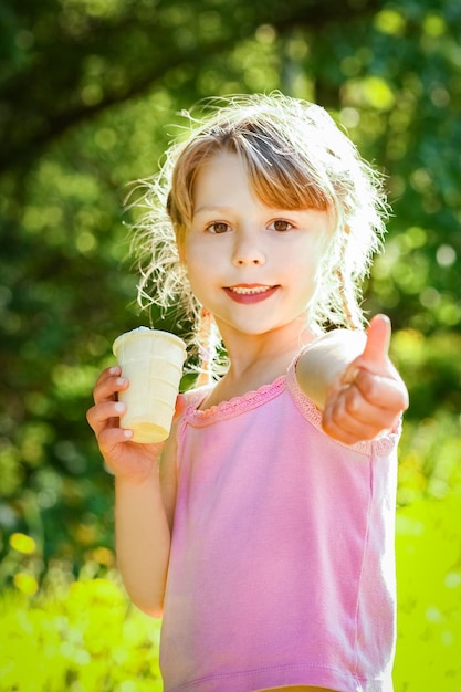 Niño comiendo helado en el parque al fondo