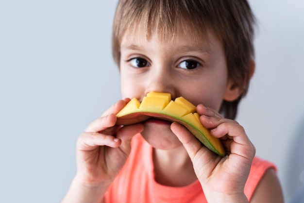 Foto un niño comiendo mango.