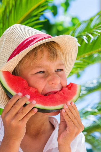 Niño comiendo sandía madura roja Concepto de vacaciones y vacaciones de verano