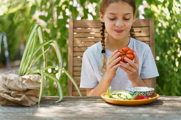 Niño comiendo tomate en la terraza