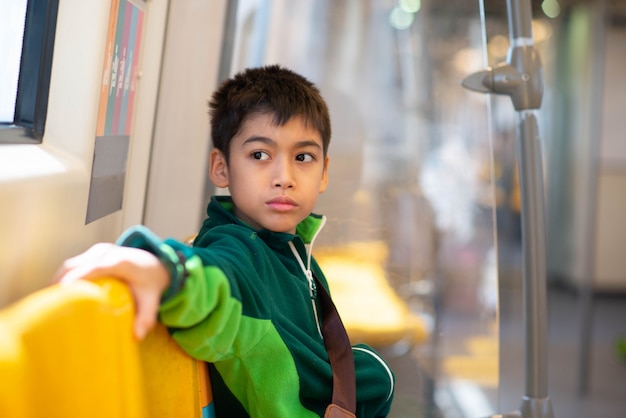 Niño comprando boleto eléctrico y caminando en la estación de tren público con la familia