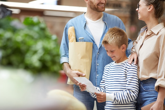 Niño comprando víveres con la familia