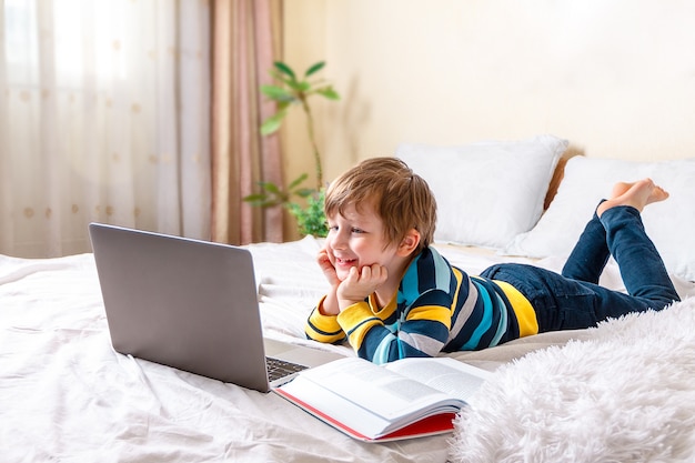 Niño, con, computador portatil, en cama