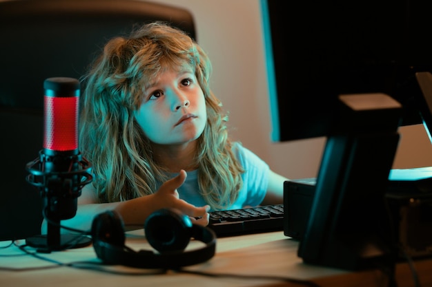 Niño con computadora pc en la noche un niño bonito aprende una lección usando una computadora de escritorio en casa