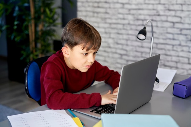 Niño concentrado usando portátil durante la educación