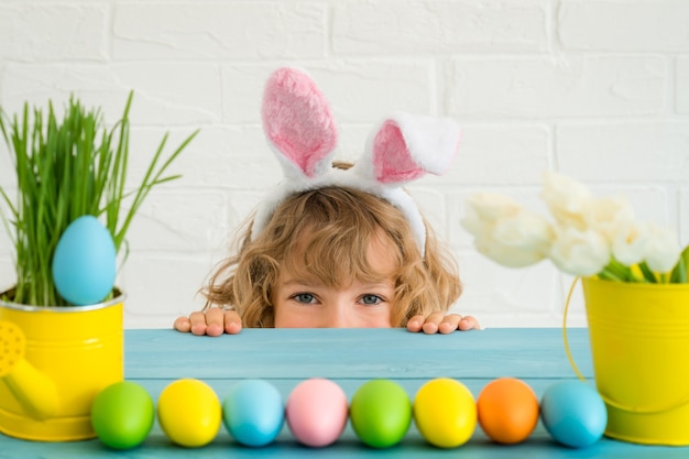 Niño y conejito de Pascua. Niño jugando con conejo y huevos.