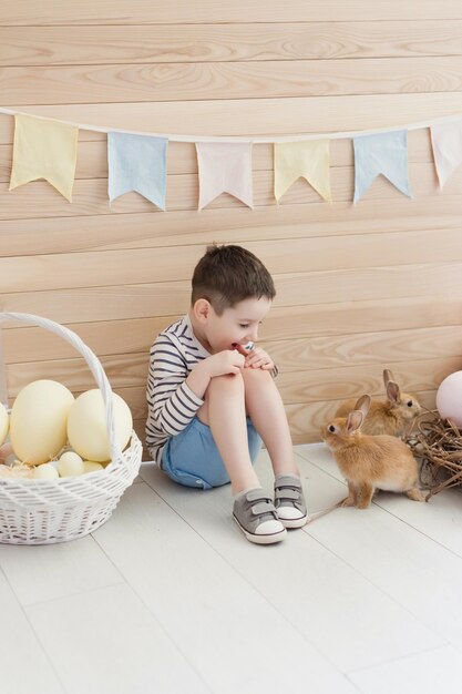 Foto niño con conejo y decoración de pascua